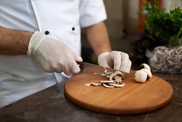 istock Chef cuts  mushrooms on a wooden board 540403196
