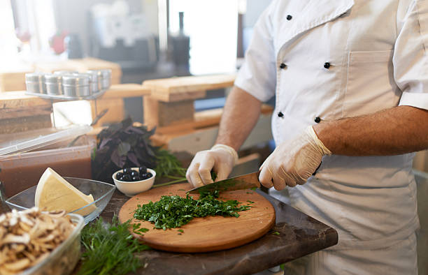 istock Cook chops parsley with a knife on  board 540404848