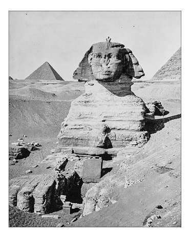 Antique photograph of the Great Sphinx of Giza (Egypt) in a frontal picture taken during the 19th century with the pyramids (Pyramid of Khafre and Great Pyramid of Giza) in the background on the Giza Plateau.