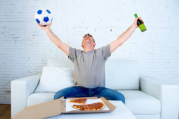 istock fanatic man with beer watching television football celebrating goal 540489000