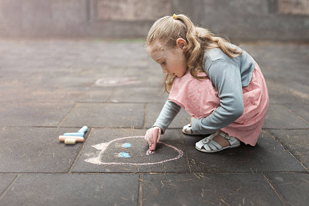 istock little girl draws chalk on asphalt 540490040