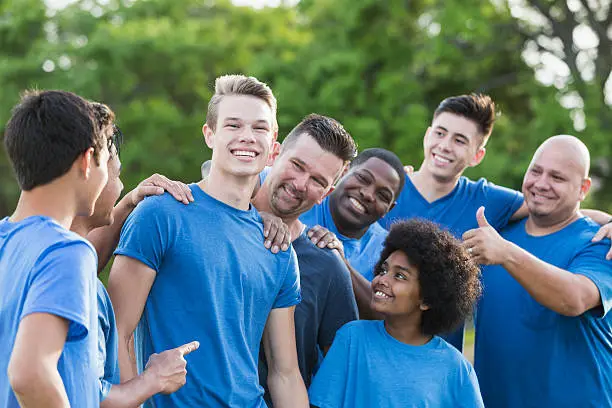 Photo of Group of teenage boys and fathers wearing blue shirts