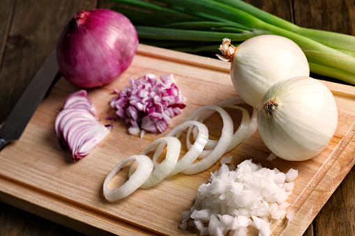 Group of sliced red, green and white onions ready for cooking on cutting board. Vegetables are important part of healthy eating and provide a source of many nutrients, including fiber, potassium, folic acid and vitamins A, E and C. Options like spinach, tomatoes, broccoli and garlic provide additional benefits, transforming them in superfood. USDA's MyPlate encourages making half your plate fruits and vegetables.  People who eat vegetables and friuts as part of their daily diet have a reduced risk of many chronic diseases.