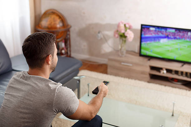 istock Man watching soccer in living room 540494092