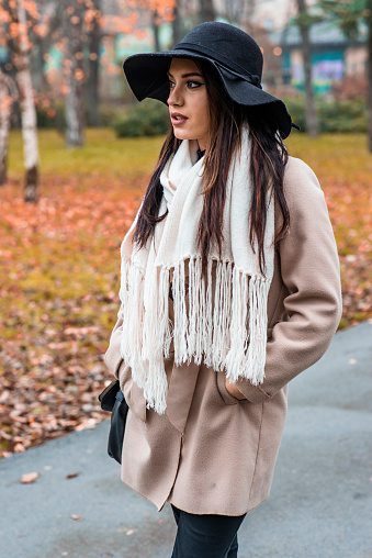 Pretty young woman with a hat at autumn park