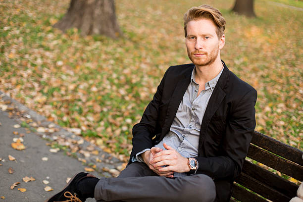 istock Young man on bench at autumn park 540499654