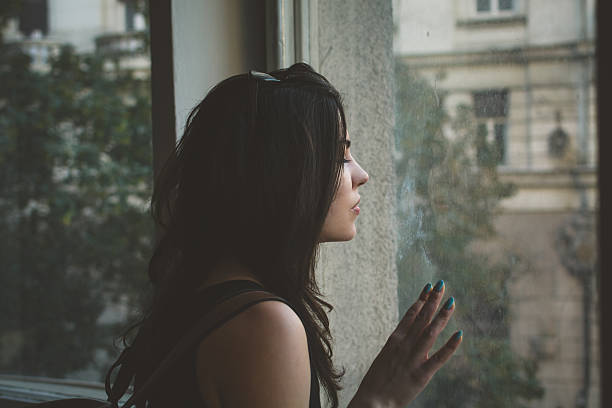 istock Sad woman looking through the window 540504304