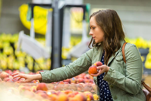istock Beautiful woman picking out fruit 540506142
