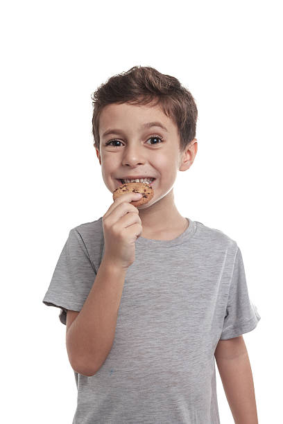 menino comendo biscoitos com gotas de chocolate - little boys breakfast caucasian child - fotografias e filmes do acervo