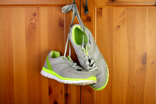 Sneakers hang on a wooden closet