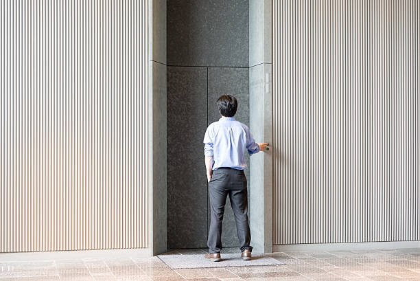 istock Japanese businessman standing and waiting for elevator 540510276