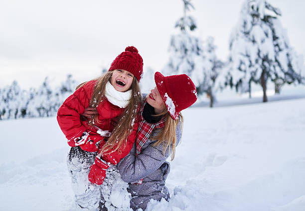 istock funny mom and daughter playing in  snow-covered park  winter 540510468