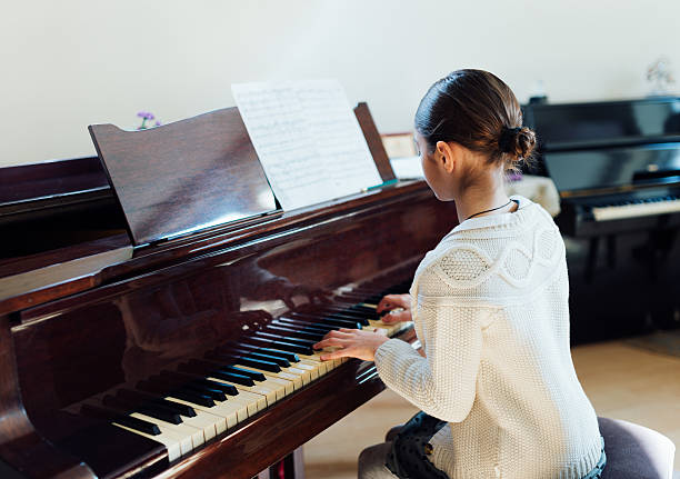 istock girl playing  grand piano 540510954