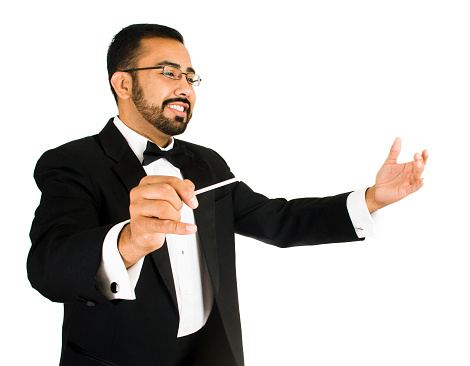 A young mexican american musician wearing a tuxedo with a conductor's baton
