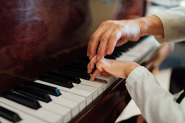 istock hand of an experienced pianist  helping young students 540511024