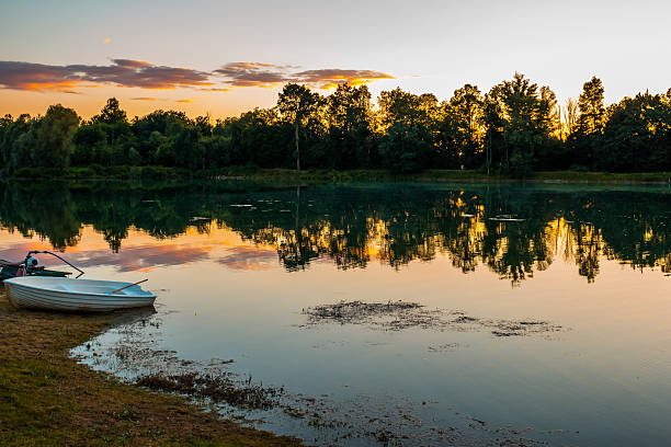 istock Lonely Boat At Lake On Beautiful Orange Summer Sunset 540511236