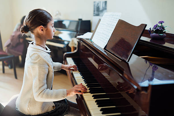 good student plays  piano at a music school
