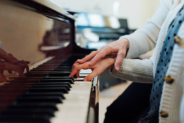 istock music teacher helps  student to play correctly 540511928