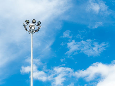 High voltage spotlight pole for sport stadium or street round by cloud and blue sky background