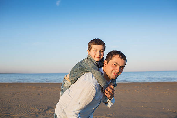 istock Father takes his little son on his back 540515388