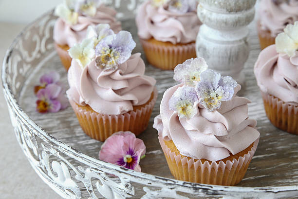 istock Purple cupcakes with sugared edible flowers on vintage cake stand 540515530