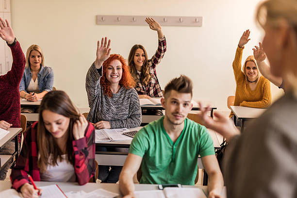 istock Happy redhead student raising hand to answer teacher's question. 540518068