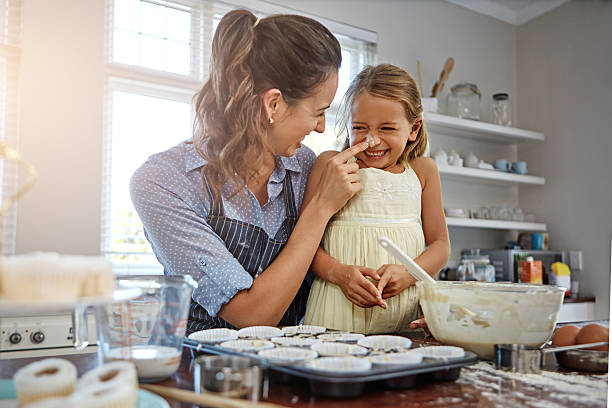 nous avons aussi amusant quand cuisson au four - mother cooking daughter child photos et images de collection