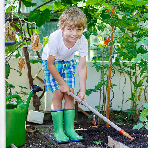 istock little kid boy working with garden hoe in greenhouse 540523848