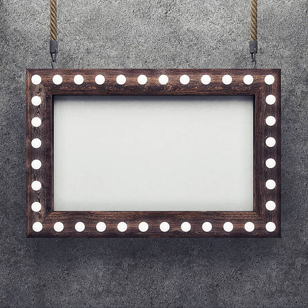 istock Wooden frame on concrete background illuminated by light bulbs 540524696