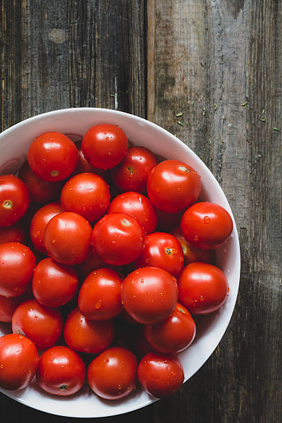 istock Group of tomatoes in bowl on wooden backdrop 540526648