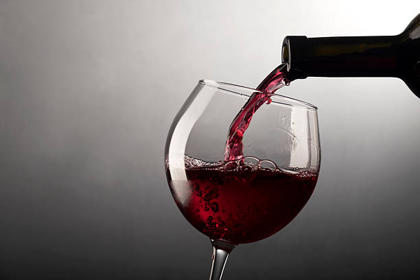 istock Red wine pouring into wine glass 540527330