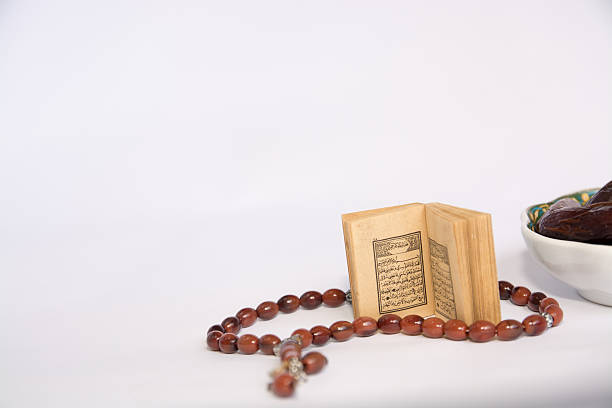 istock Koran and dates with prayer beads on white background 540529570