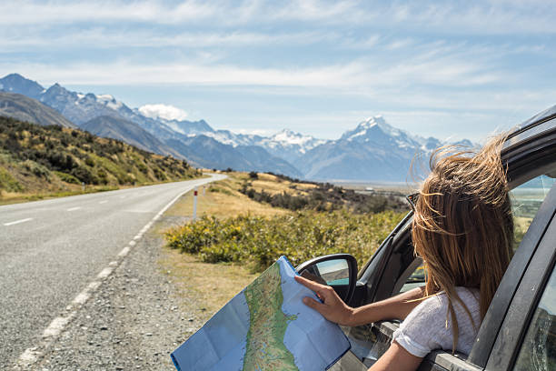 portrait de jeune femme regardant la carte en voiture - map road trip photos et images de collection