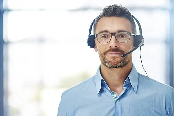 Portrait of a mature businessman wearing a headset in an office