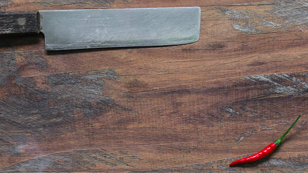 Pimento red-handled knife old. On a wooden background