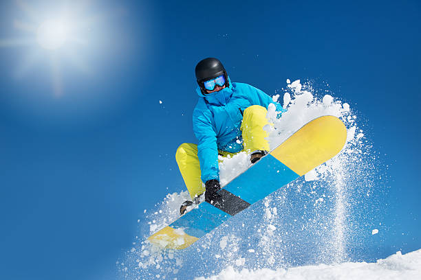 Hitting a jump Active snowboarder in the air hitting a jump snowboarding stock pictures, royalty-free photos & images
