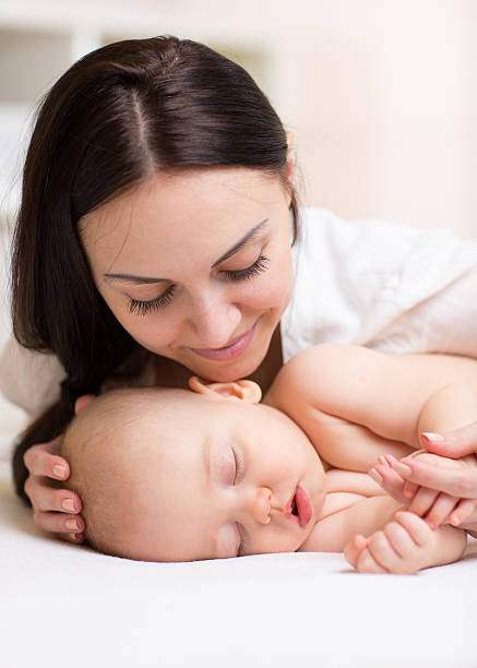 istock Happy beautiful woman looking at sleeping son baby 540566762