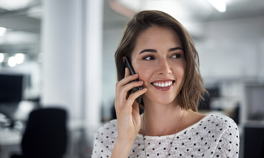 Shot of a woman talking on her phone at the office