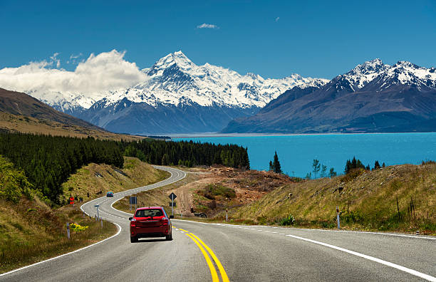 Red car on the road to Mt.Cook,New Zealand Red car going to the beautiful landscape lake tekapo, Mt.cook, Lupines fields, South island New Zealand new zealand photos stock pictures, royalty-free photos & images