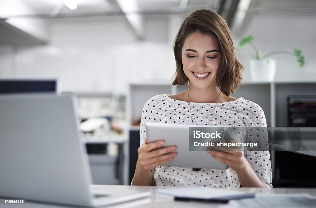 Make technology work for you Shot of a businesswoman using her tablet at her desk Digital Tablet Stock Photo