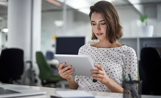 Shot of a businesswoman using her tablet at her desk