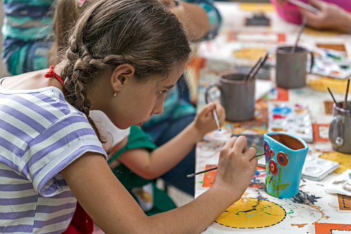 Timisoara, Romania - June 1, 2016: Girl who paints a ceramic bowl. Workshop organized by the City Hall Timisoara with the occasion of the International children Day.