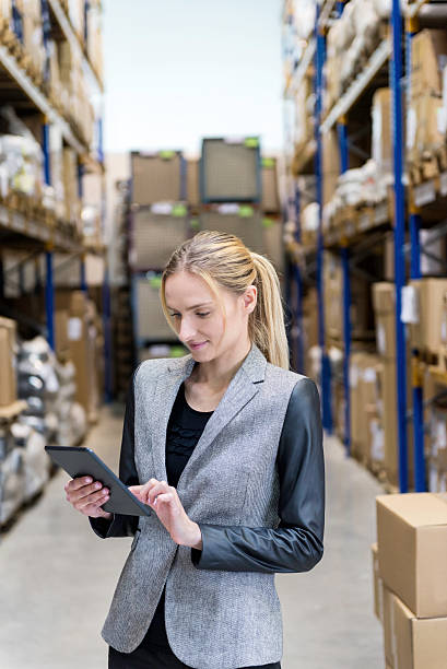 istock Young businesswoman working on tablet in storage 540568476