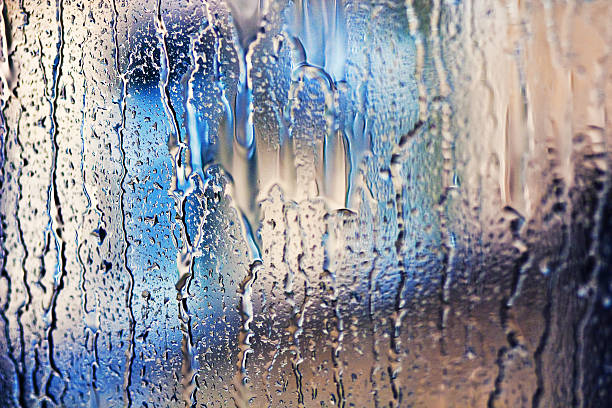 istock Stream of water in heavy rain. Raindrops on window pane. 540569054