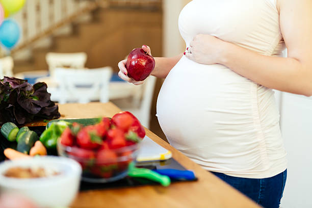 mulher grávida dieta saudável - women eating fruit food - fotografias e filmes do acervo