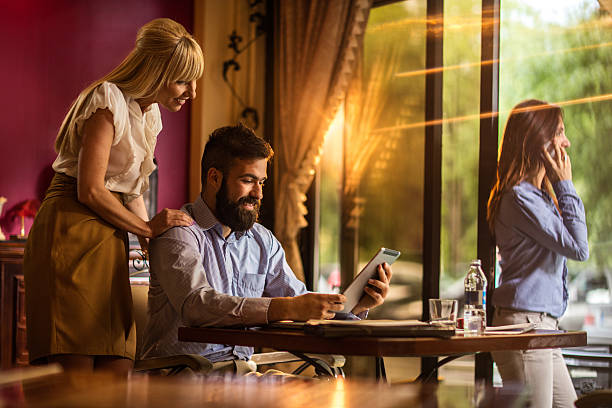 istock Smiling business people reading something on touchpad in a cafe. 540569178