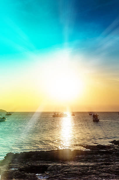 Sunset at Adriatic sea with boats anchored and island Cres in the background.\