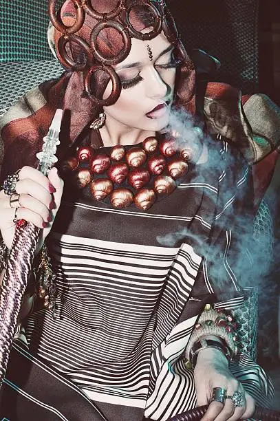 Photo of girl in a scarf smoke hookah