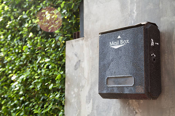 istock Old black stained metal mailbox on a gray house wall 540570626
