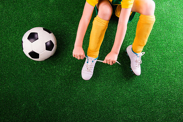 istock Unrecognizable little football player against green grass, studi 540571538
